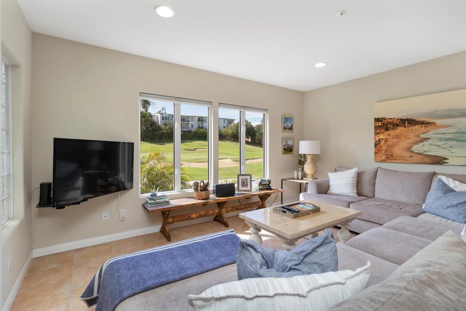 Furnished living room with a sectional sofa and windows overlooking a golf course.