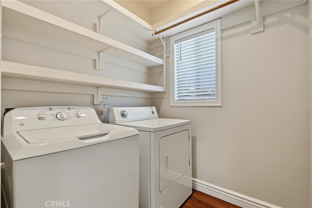 Laundry room with a top-loading washer, front-loading dryer, and built-in shelving.