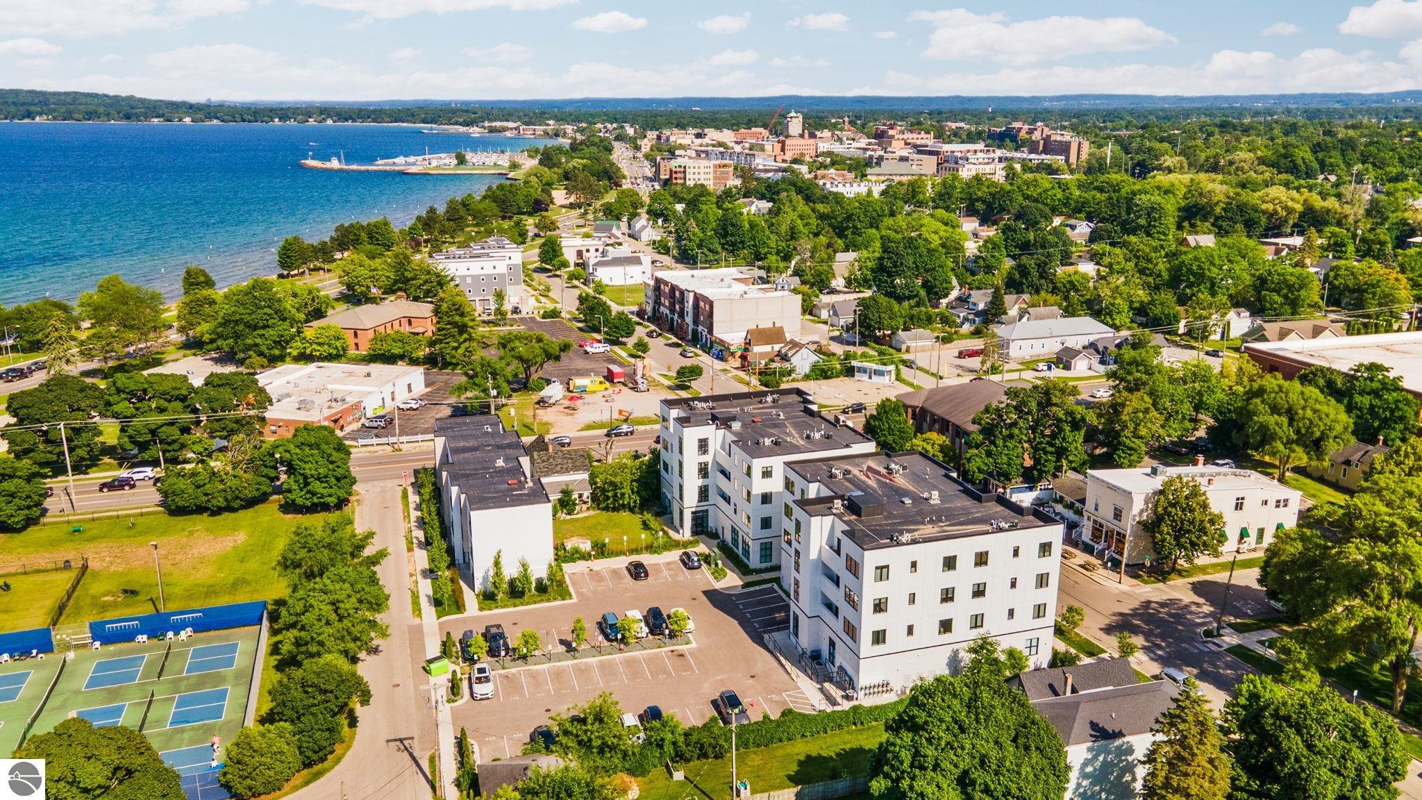 Aerial view of Traverse City and Lake Michigan, with downtown buildings and tennis courts.