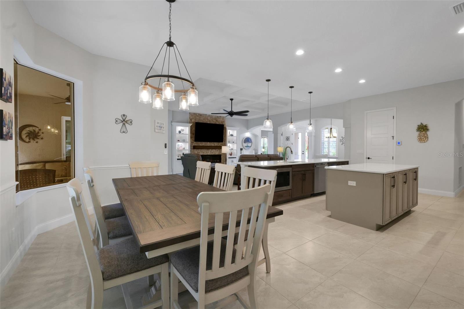 Open-plan kitchen and dining area with a large island and stone fireplace.