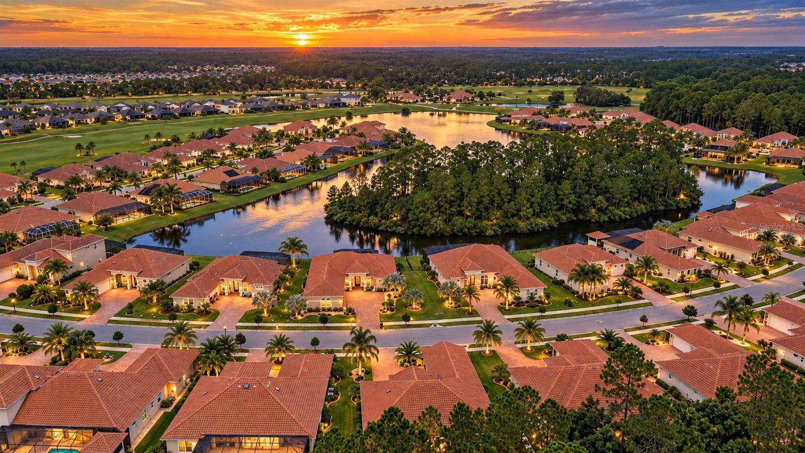 Aerial view of red-roofed homes and winding waterways at sunset.