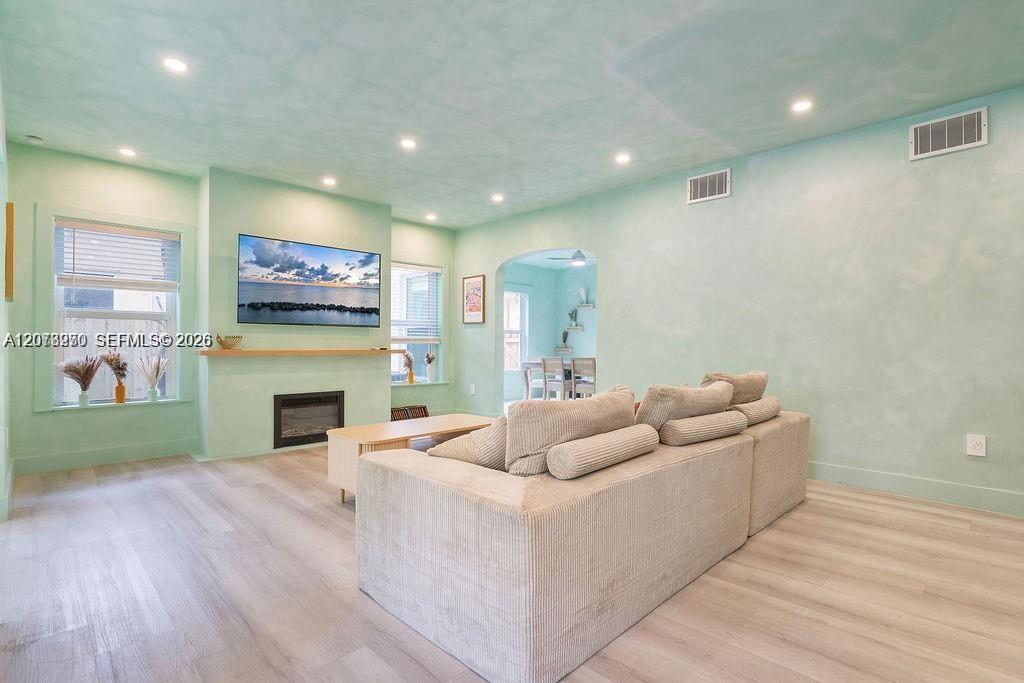 Living room with a cream sectional sofa, fireplace, and television against mint-green walls.