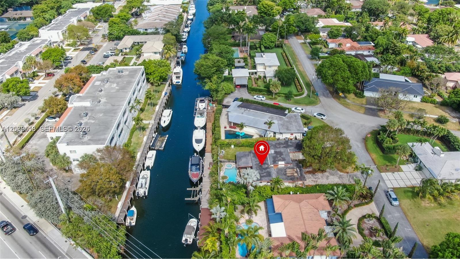 Aerial view of a canal-side home marked in red, with a pool and boats along the canal.