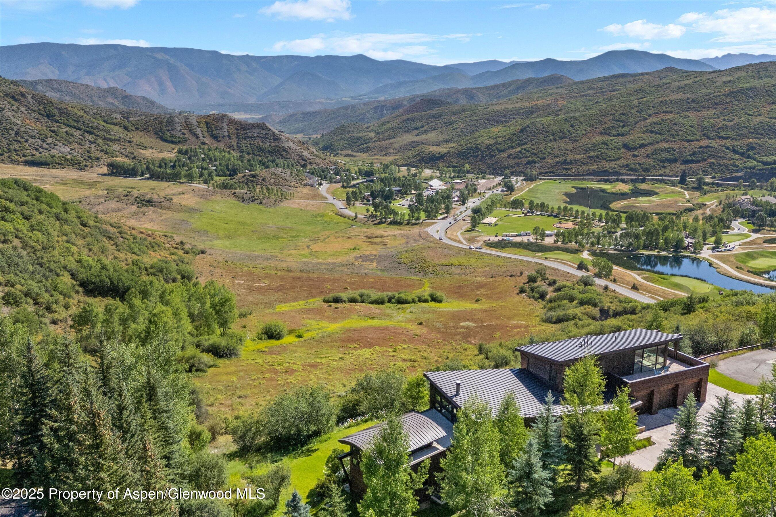 Modern home overlooking a mountain valley and landscaped golf-course grounds.
