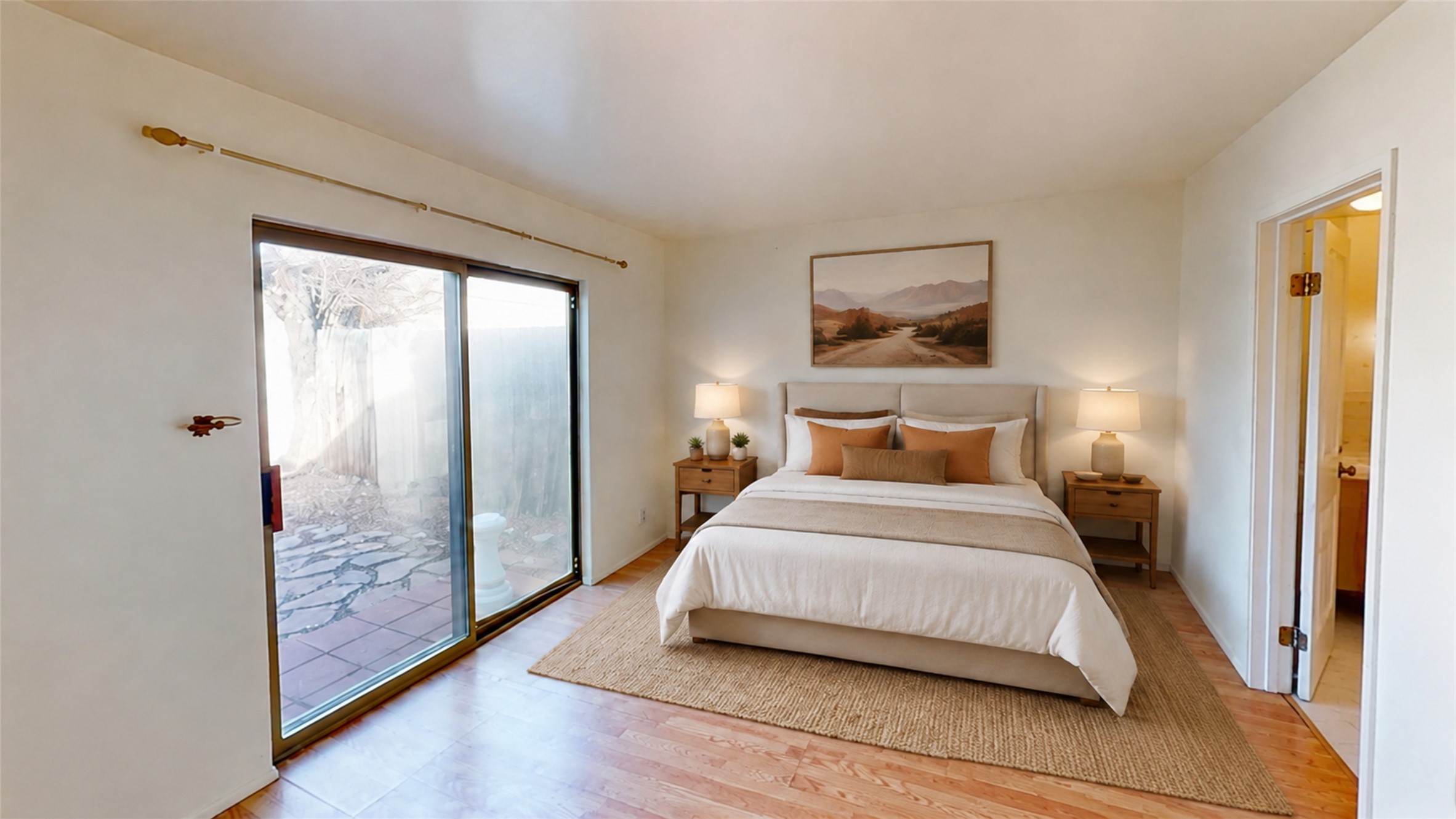 Bedroom with a king-size bed and sliding glass doors opening onto a tiled patio.