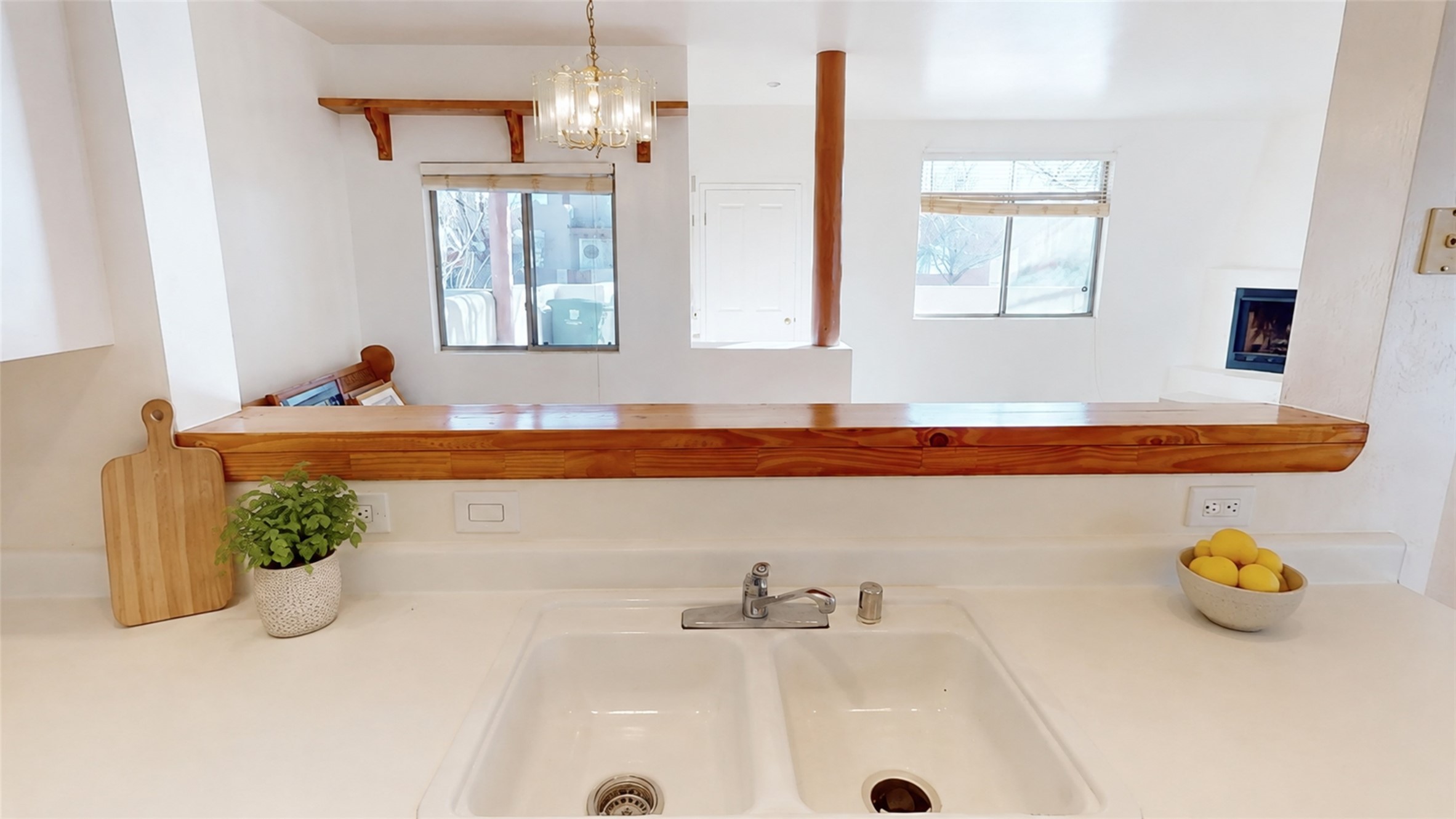Kitchen with a white double-basin sink beneath a long raised wooden bar.