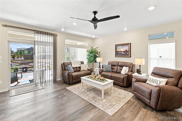 Living room with brown leather seating, a patterned rug, and sliding glass doors to a patio.