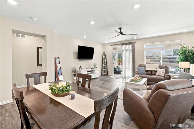 Open-plan living and dining room with brown leather seating and a dark wood dining table.