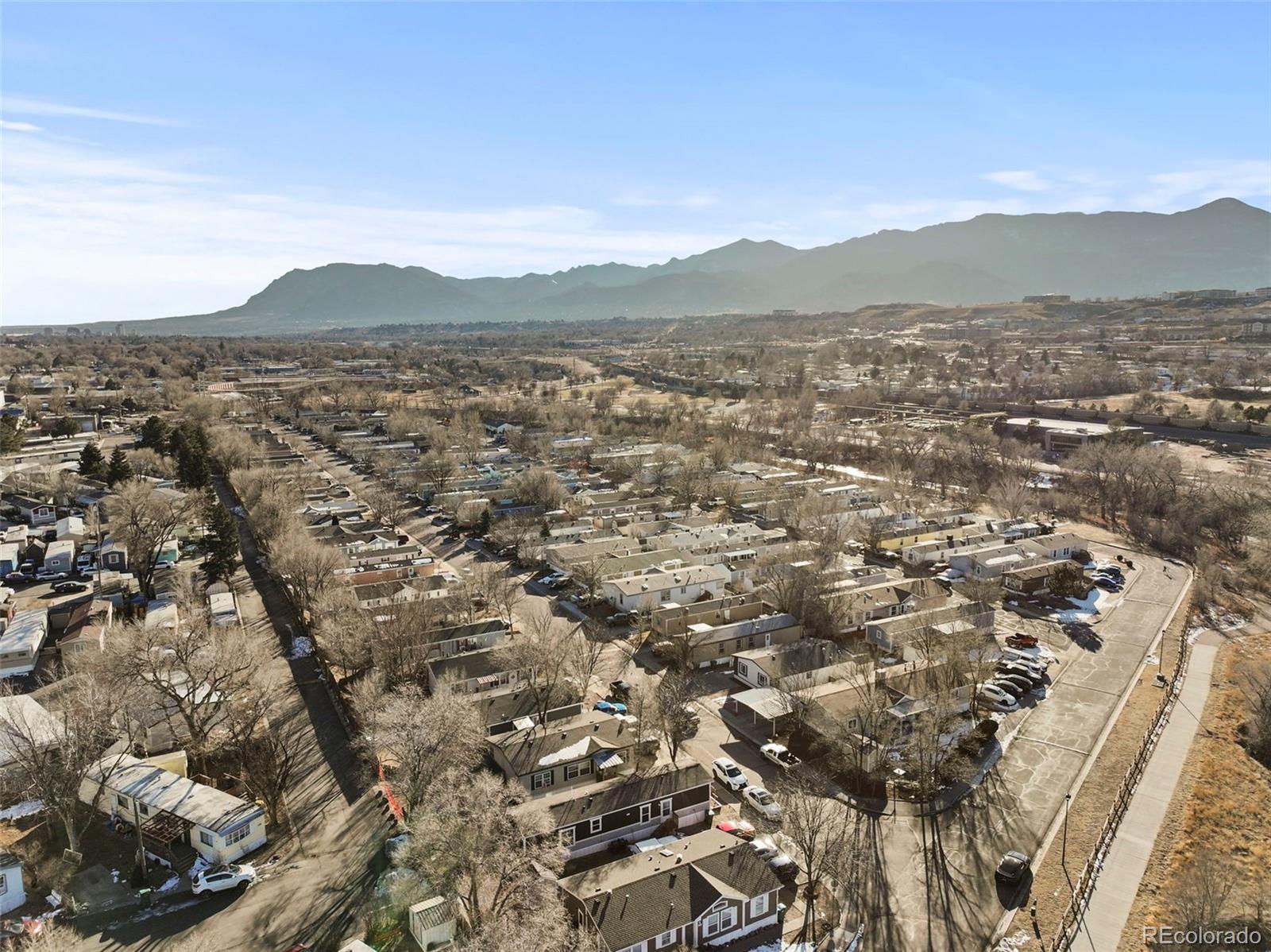 Aerial view of a residential neighborhood with rows of homes and mountain views.