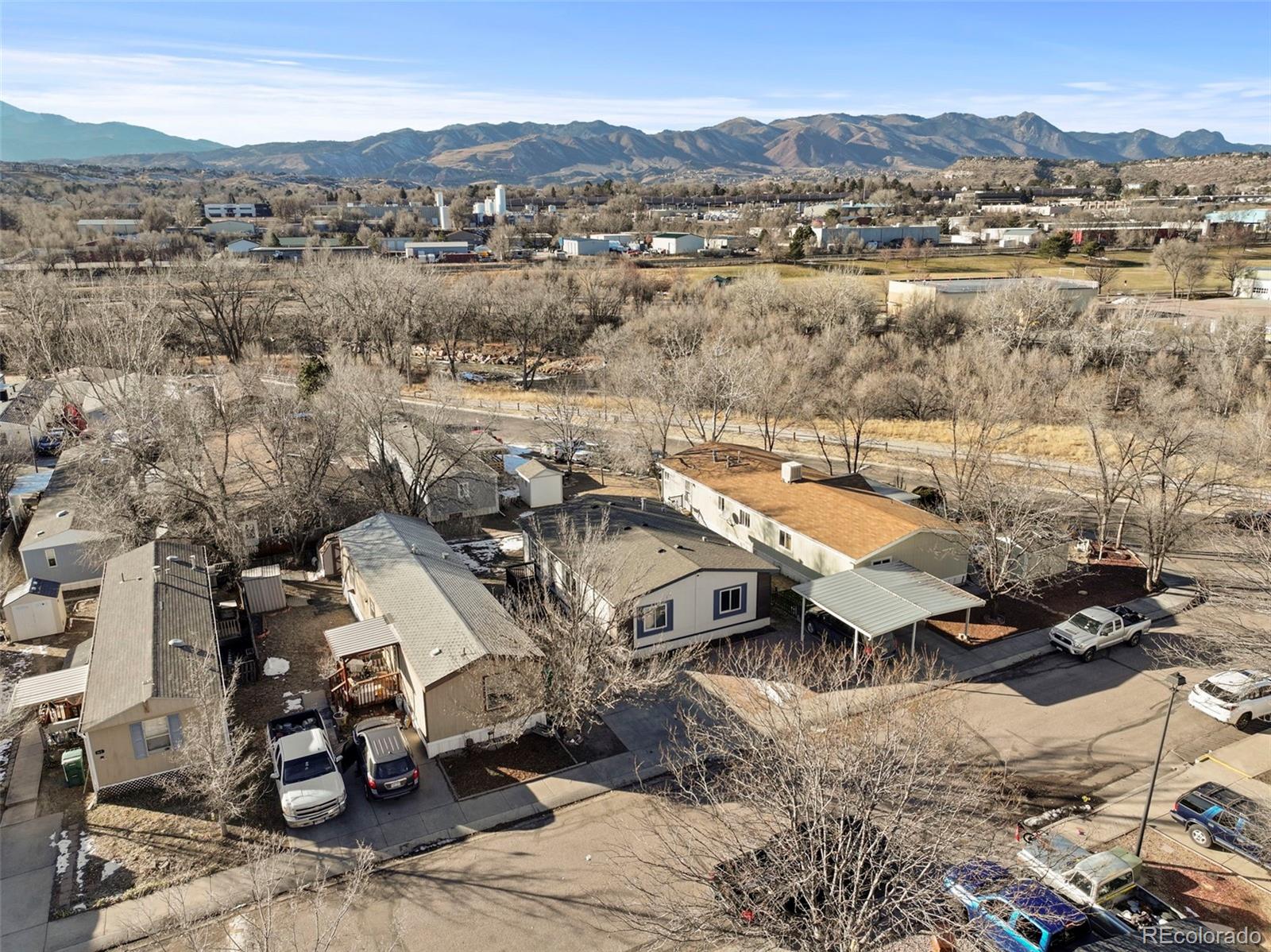 Aerial view of a manufactured-home neighborhood with the Rocky Mountains in the distance.