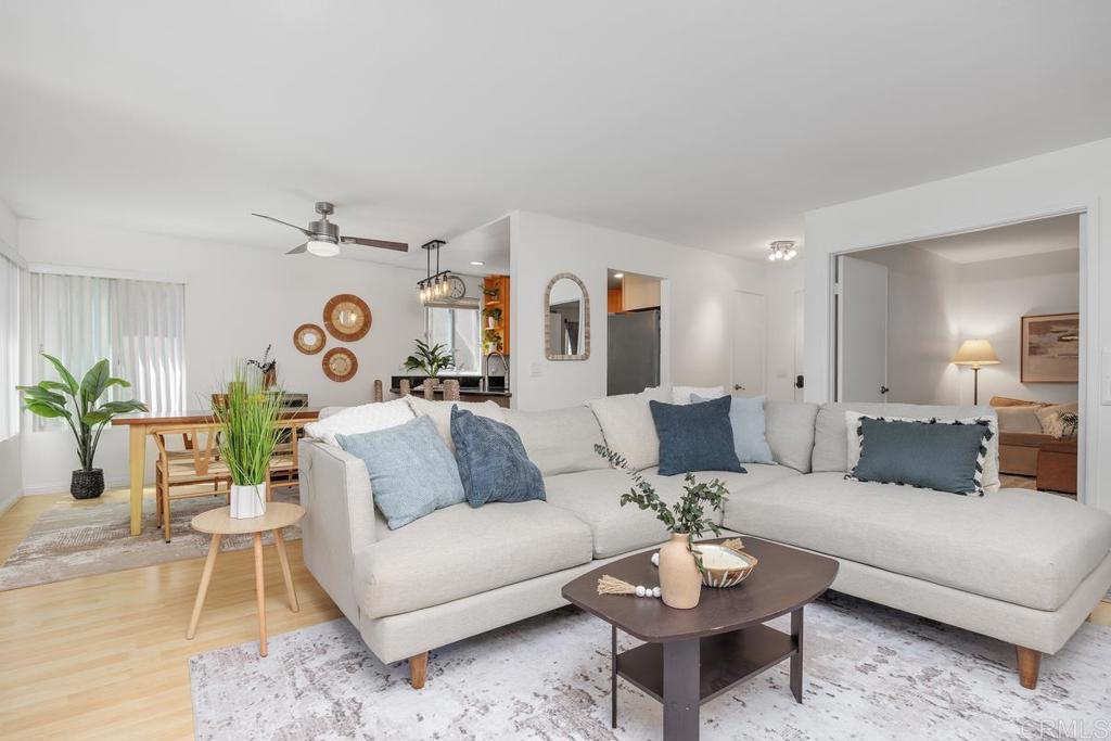 Open-plan living room with a large sectional sofa, dining area, and kitchen.