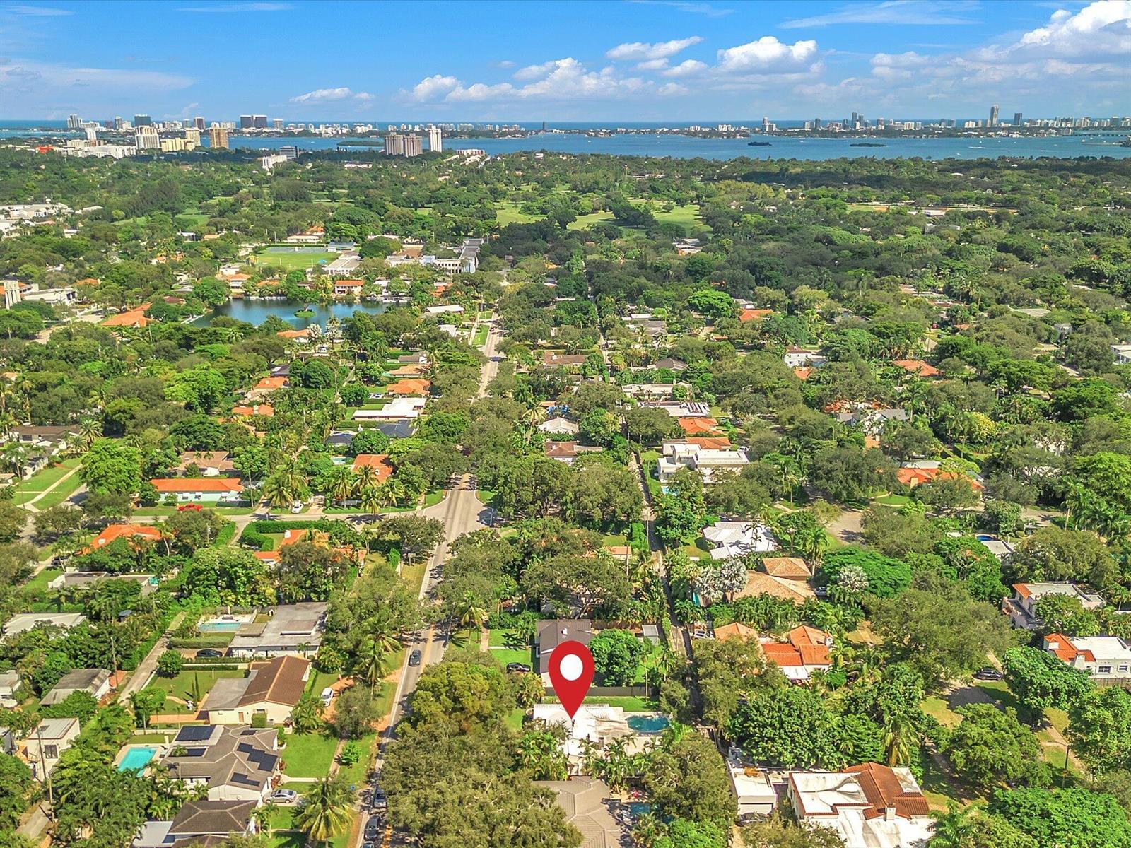 Aerial view of a Miami Shores neighborhood, with Biscayne Bay and a downtown skyline in the distance.