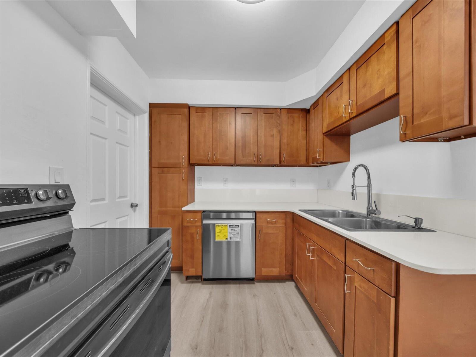 Kitchen with wood cabinets, stainless steel appliances, and a double-basin sink.