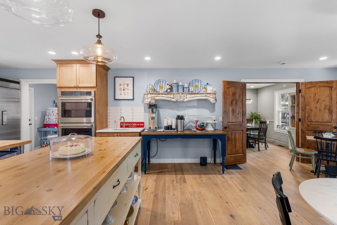 Kitchen with a large wood island, stainless steel appliances, and an open doorway to the dining area.