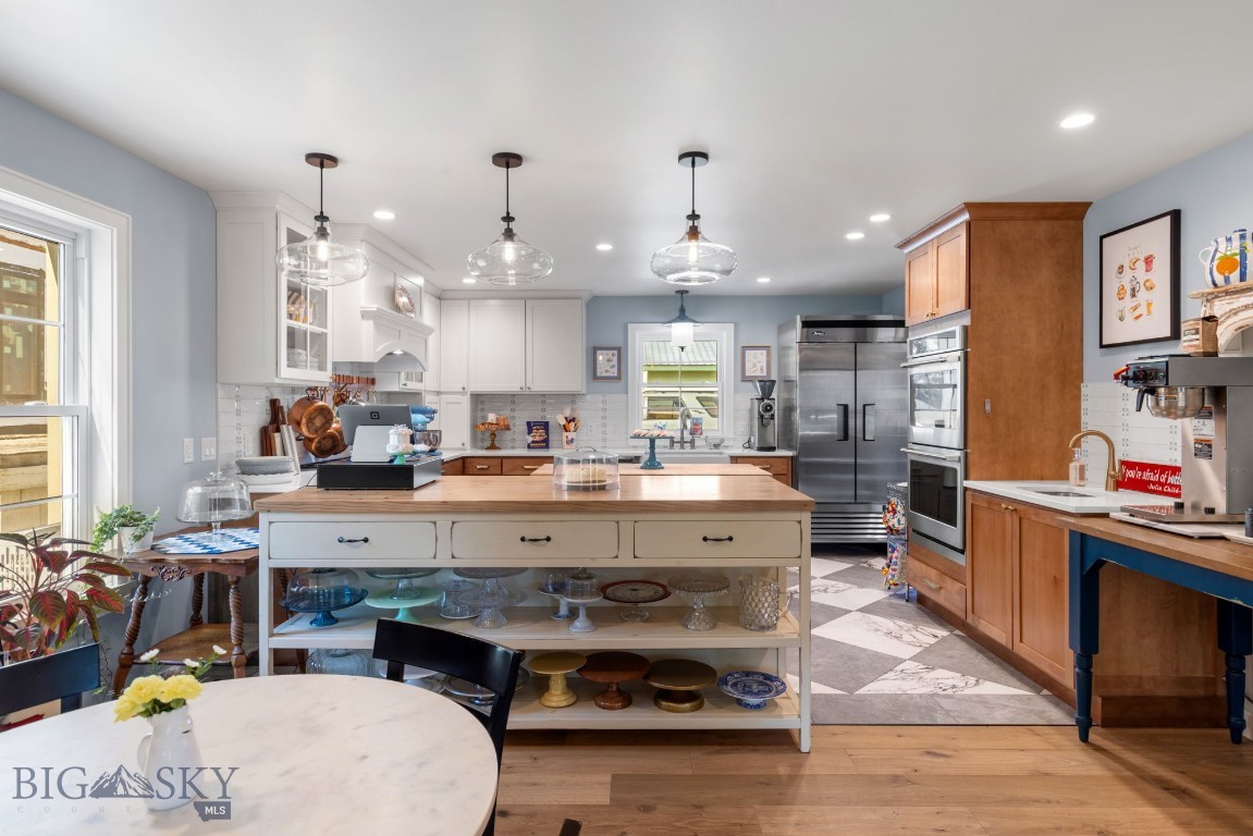 Kitchen with a display island, stainless steel appliances, and checkerboard tile floor.