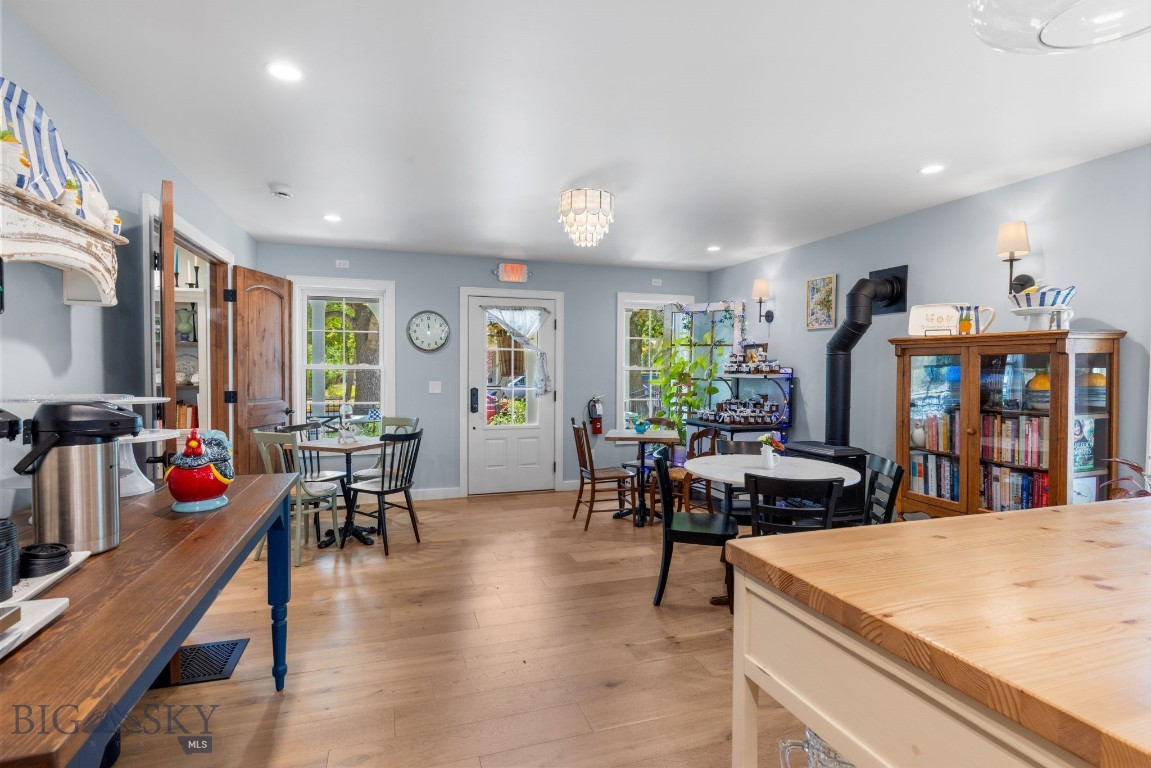 Kitchen and dining area with pale blue walls, wooden counters, dining tables, and a black wood-burning stove.
