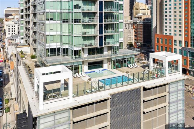 Downtown condominium tower with a rooftop pool and surrounding city buildings.