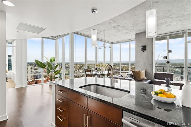 Open-plan kitchen with a stone island and floor-to-ceiling windows overlooking the city.