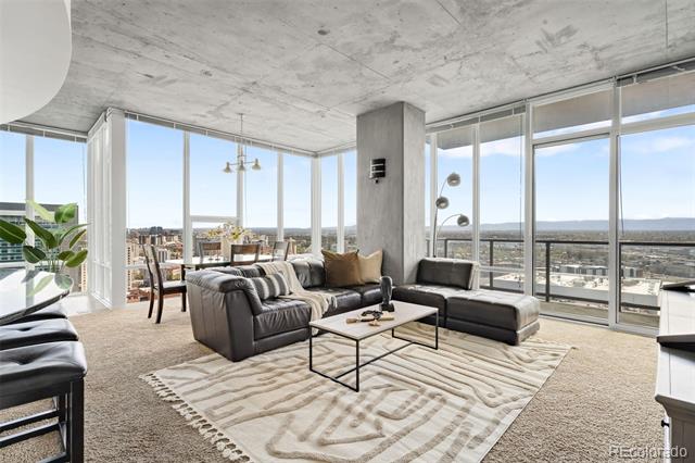 High-rise living room with floor-to-ceiling windows, a leather sectional, and Denver views.