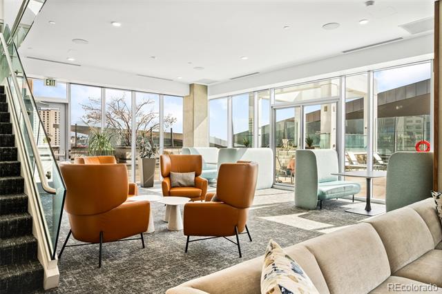 High-rise lounge with rust-colored armchairs, pale sofas, and large windows.