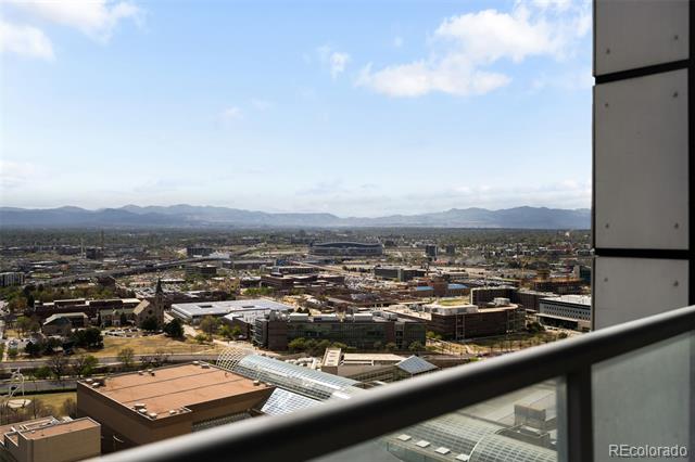 City and mountain views from a high-rise balcony.