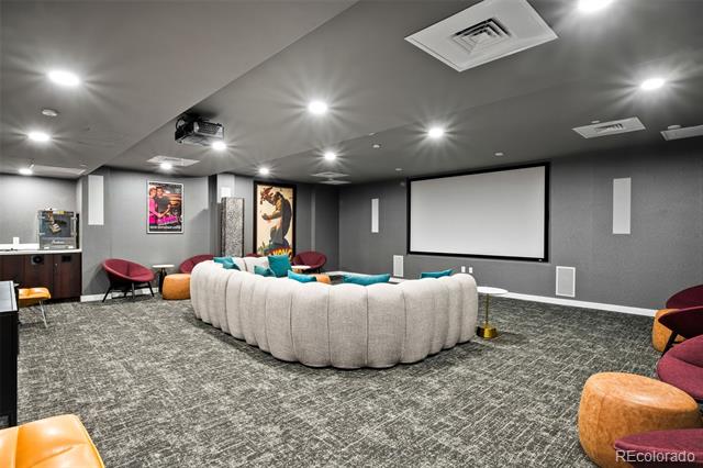 Media room with a large projection screen and curved cream sectional sofa.