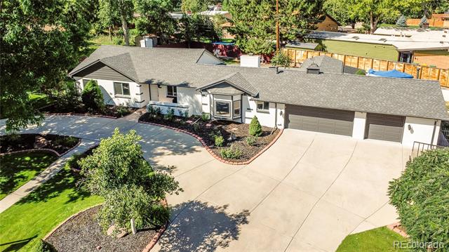 Aerial view of a single-story home with a broad driveway and three-car garage.