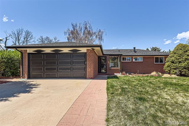 Single-story red-brick home with a dark double garage door and broad driveway.