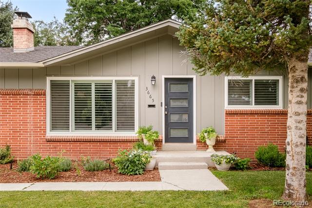 Single-story home with gray siding, red brick accents, and a centered gray front door.
