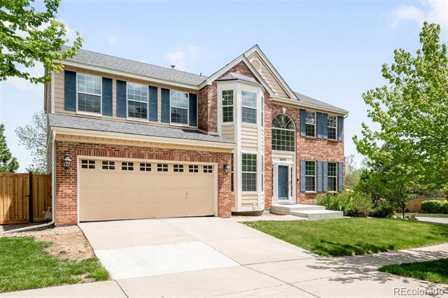 Two-story brick house with blue shutters, a tall central window, and an attached two-car garage.