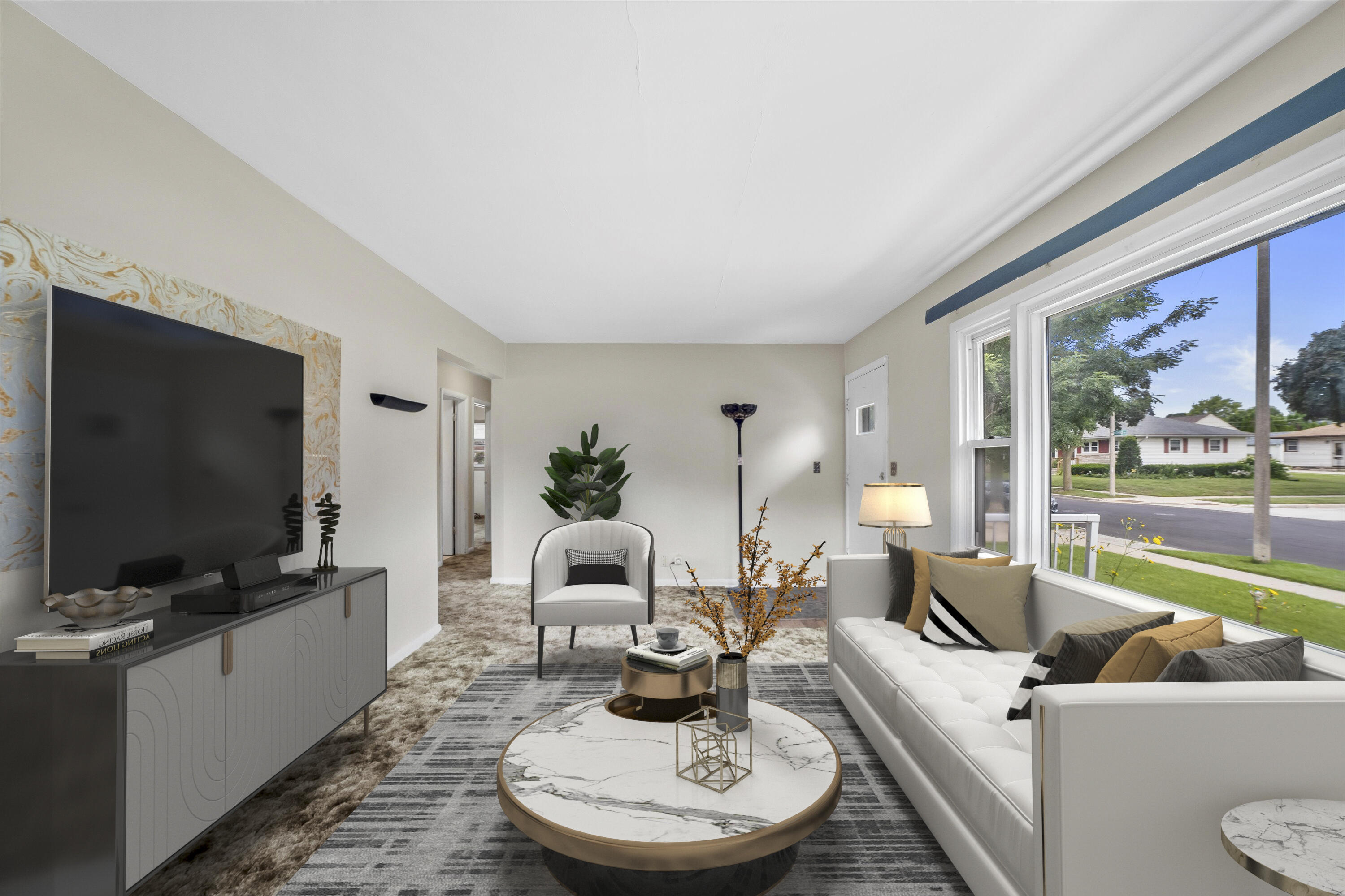 Staged living room with white seating, a marble coffee table, and broad street-facing windows.