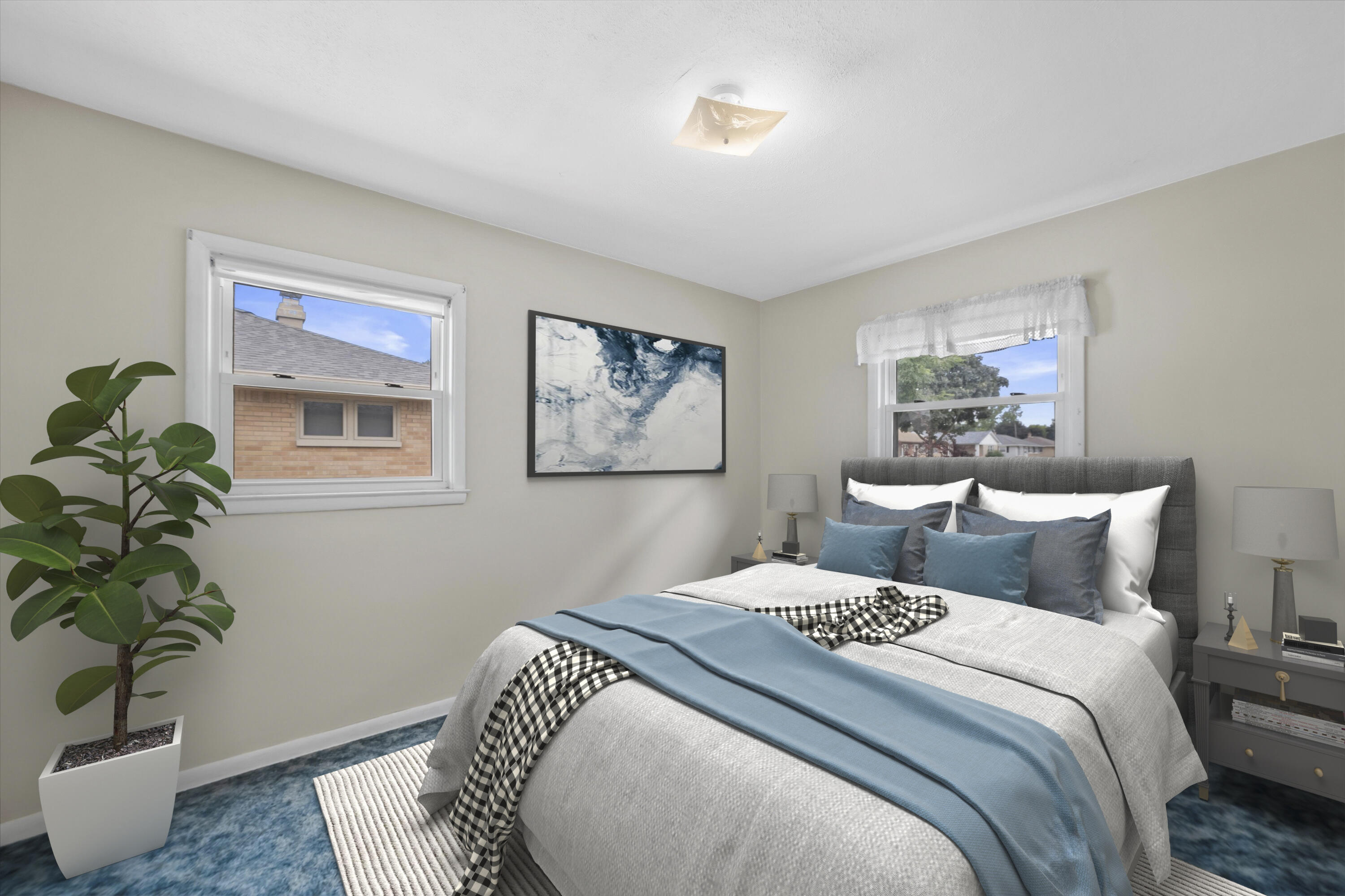 Staged bedroom with white and blue bedding, a gray headboard, two windows, and a potted plant.