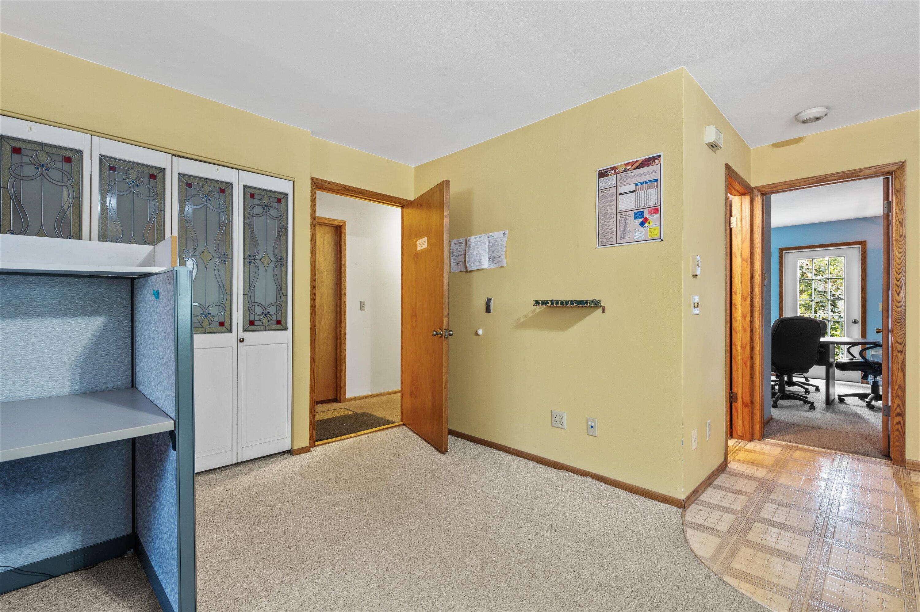 Interior room with decorative stained-glass doors and an adjoining office.