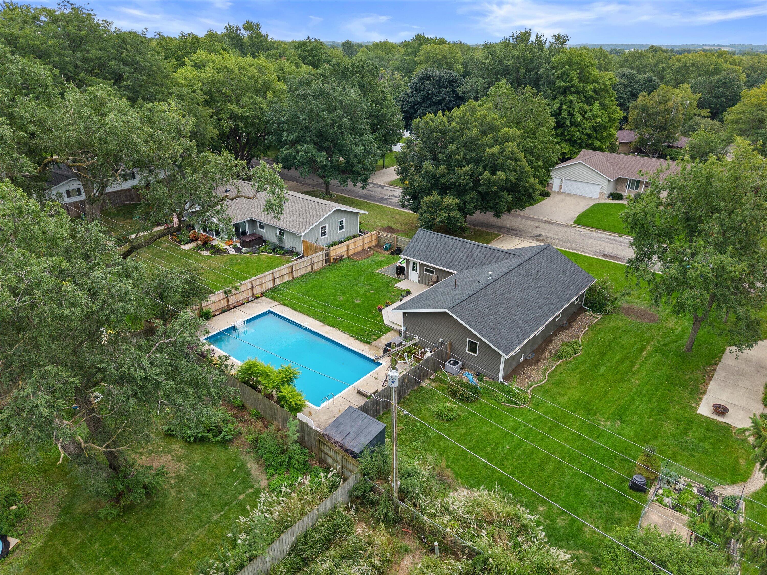 Aerial view of a gray home with a fenced backyard and swimming pool.