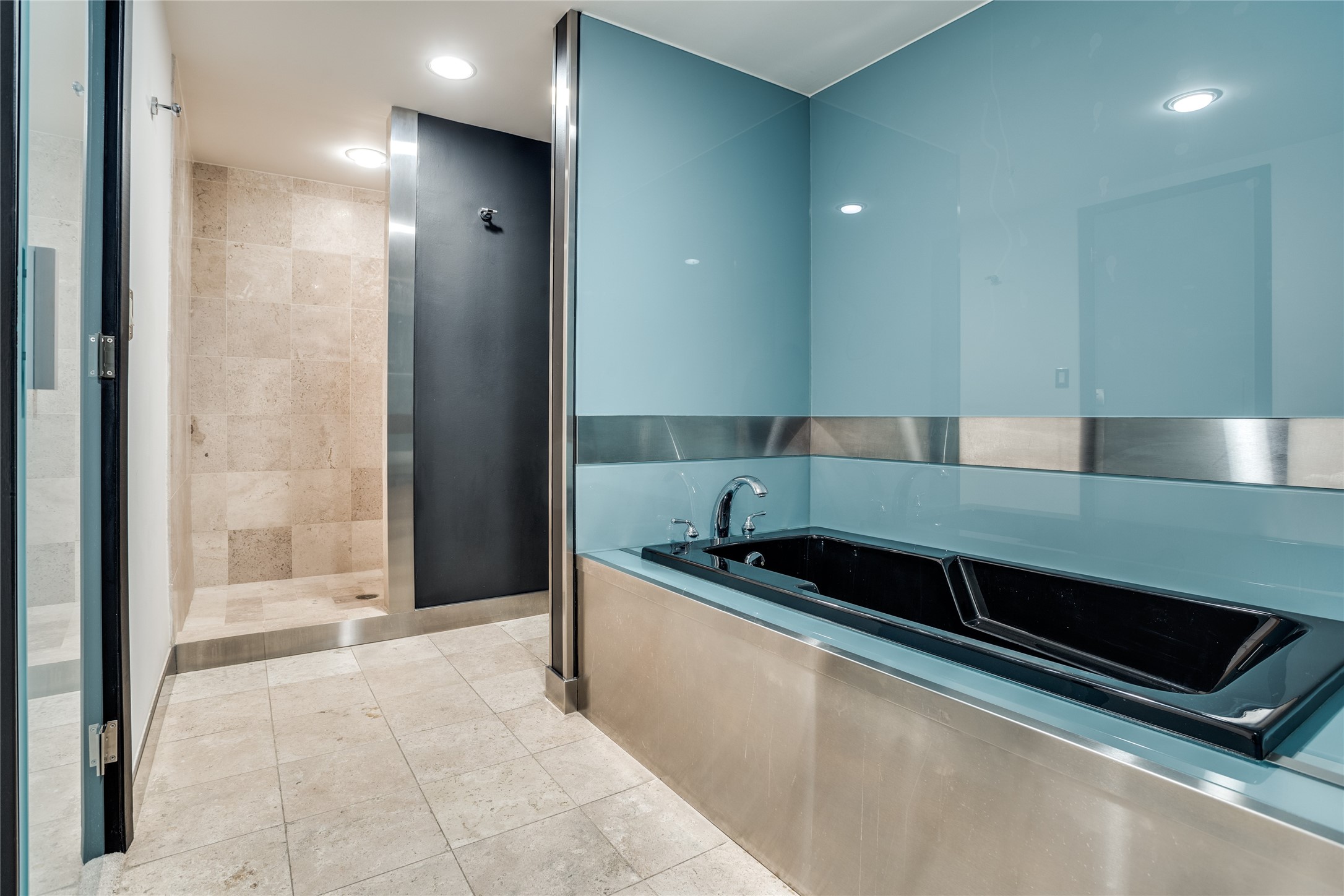 Modern bathroom with a black soaking tub, glass walls, and a tiled walk-in shower.