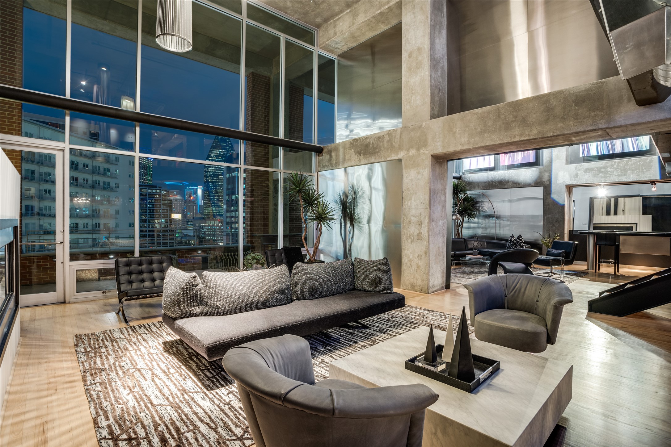 High-rise condo living room with floor-to-ceiling windows overlooking the illuminated Dallas skyline.