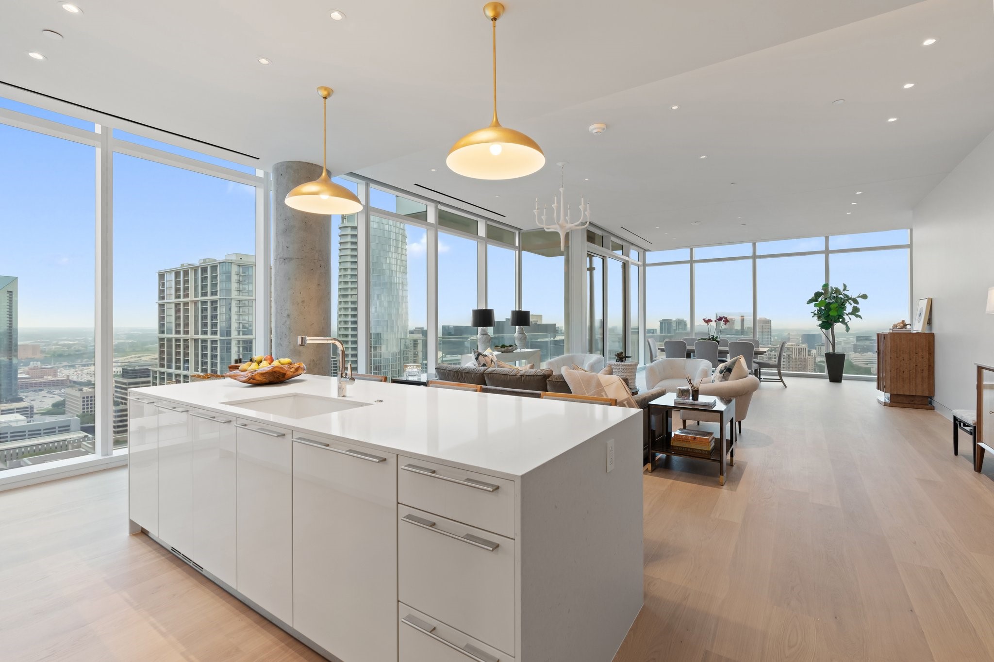 Furnished high-rise condo kitchen and living area with floor-to-ceiling windows overlooking the Dallas skyline.