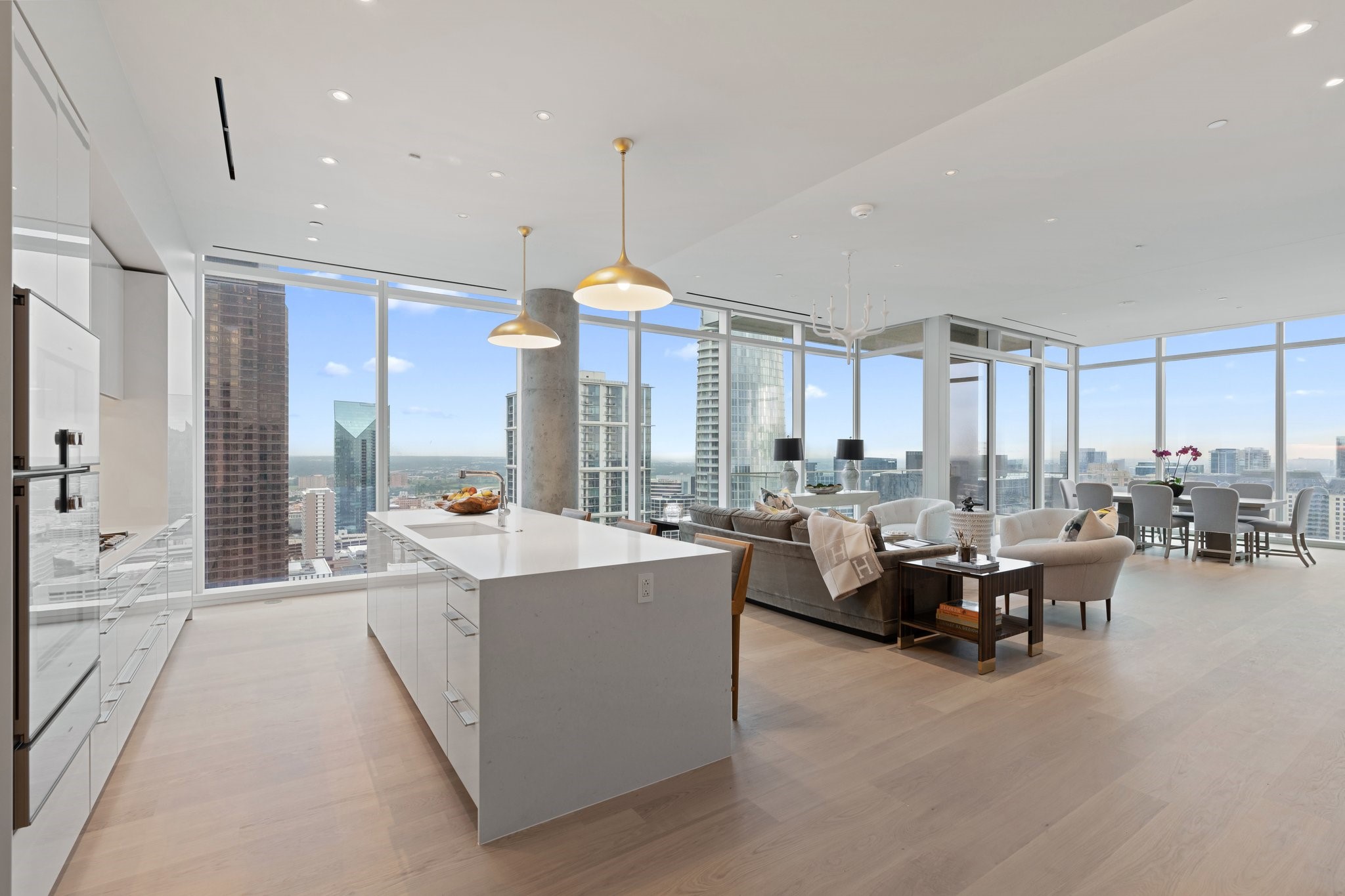 High-rise condo kitchen and living area with floor-to-ceiling windows overlooking downtown Dallas.
