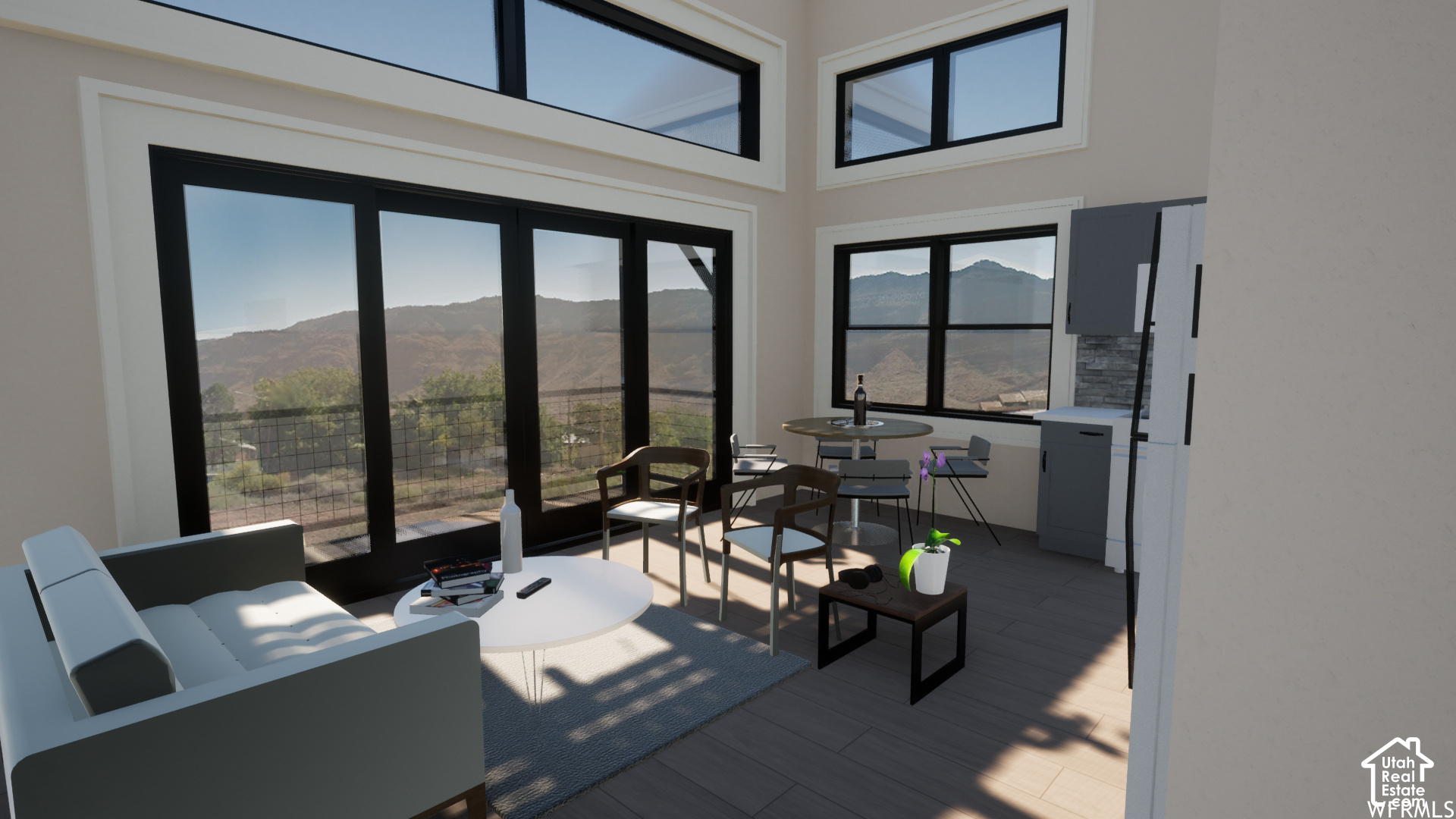 Modern living and dining area with expansive windows overlooking mountain ridges.