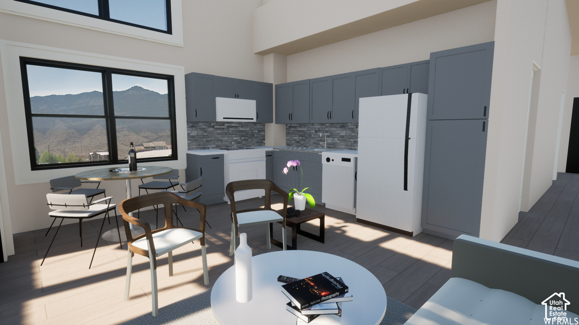Open-plan kitchen and dining area with blue-gray cabinets, white appliances, and a mountain view through the window.