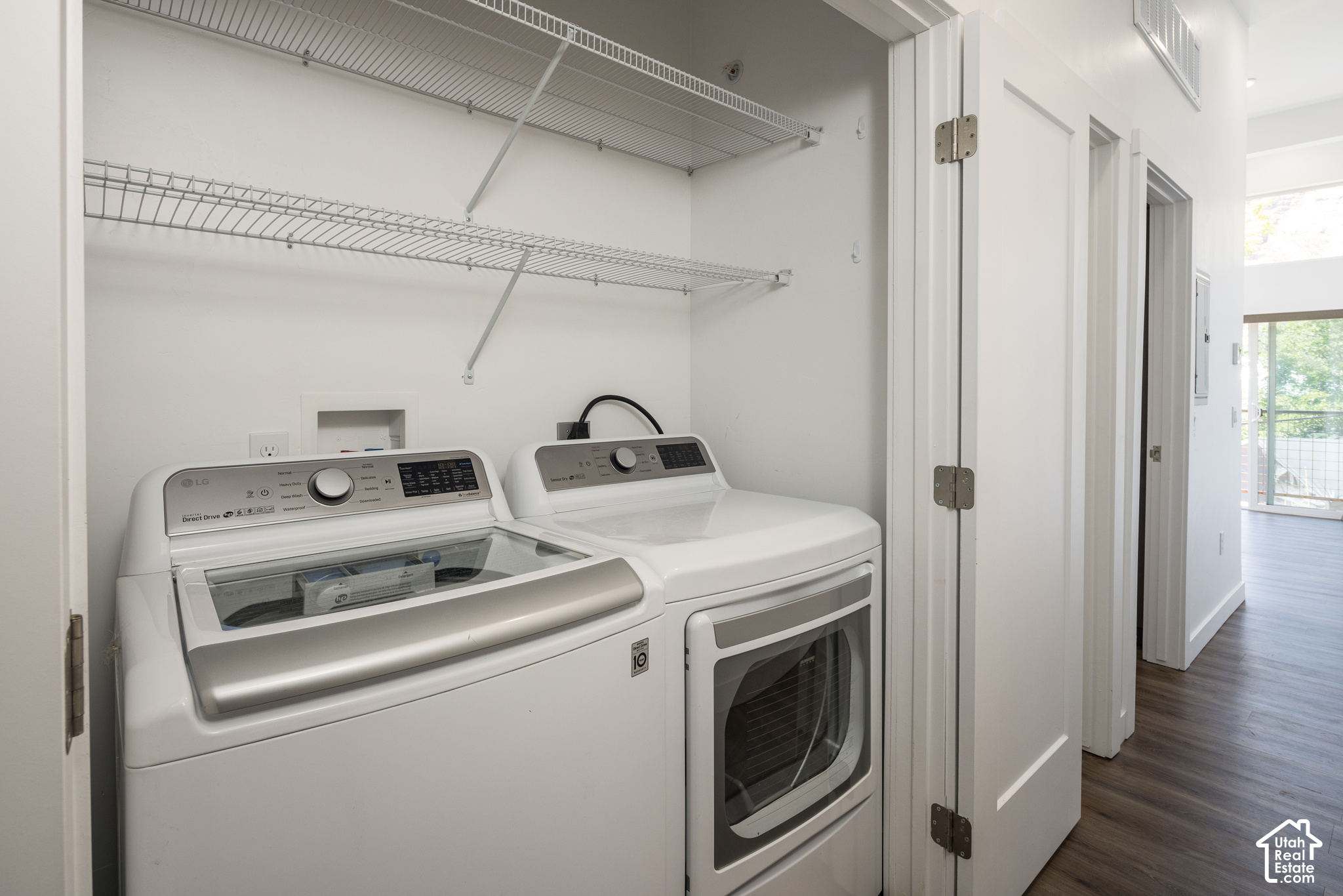 Laundry room with a top-load washer, front-load dryer, and wire shelving.