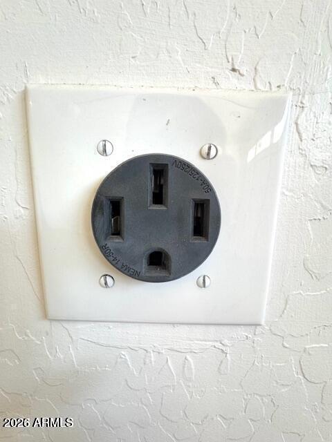 Electrical outlet mounted on a white textured wall.