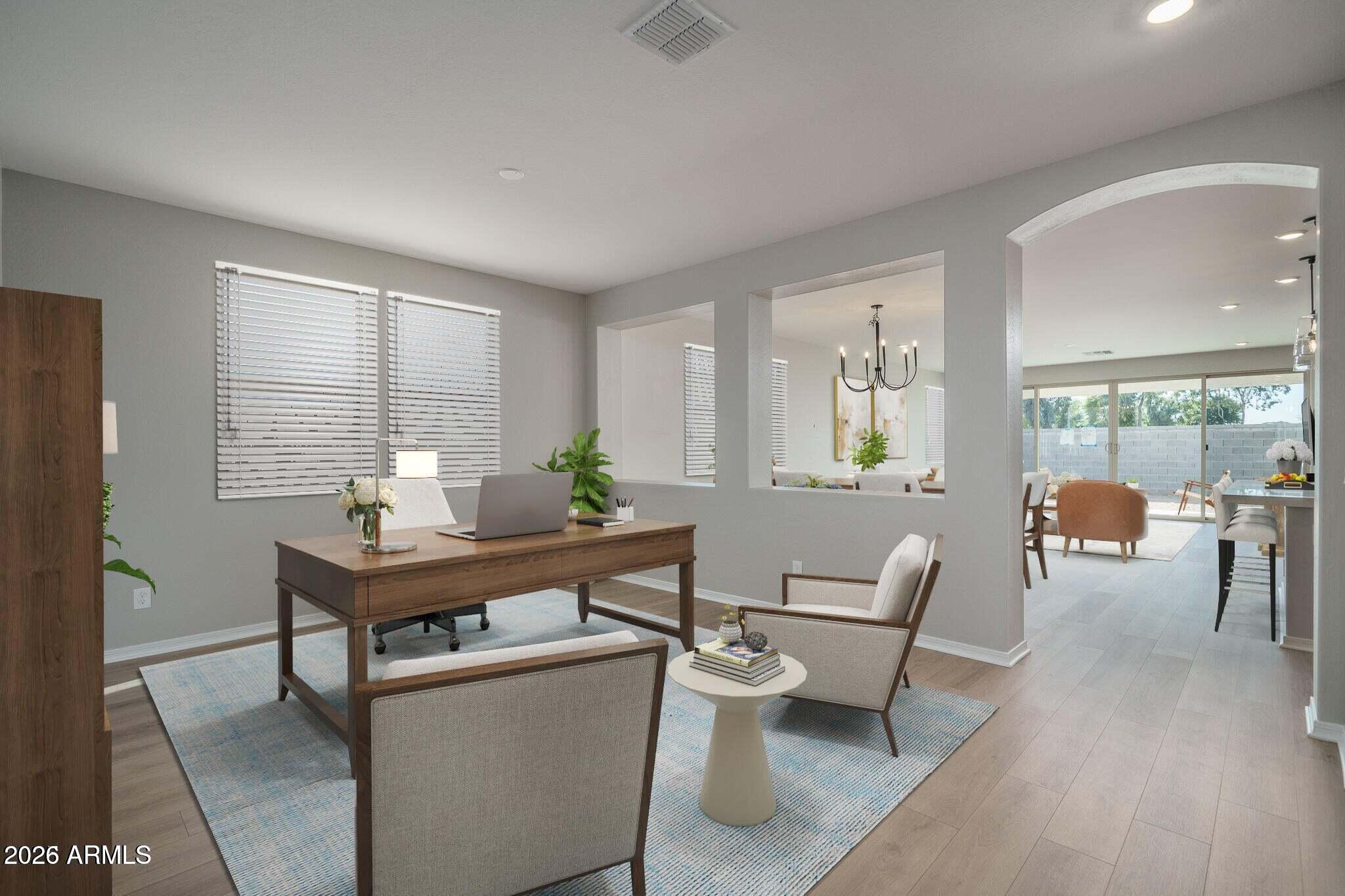 Furnished home office with a wooden desk and views through to the dining and living areas.