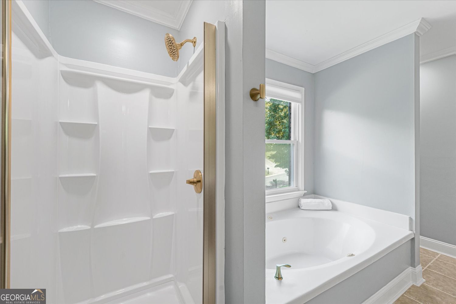 Bathroom with a white walk-in shower and a corner jetted tub beneath a window.