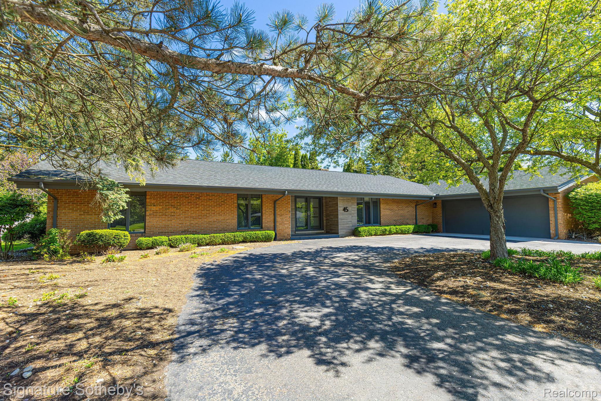 Single-story brick home with an attached garage, shaded by mature trees at 45 Maywood Avenue.