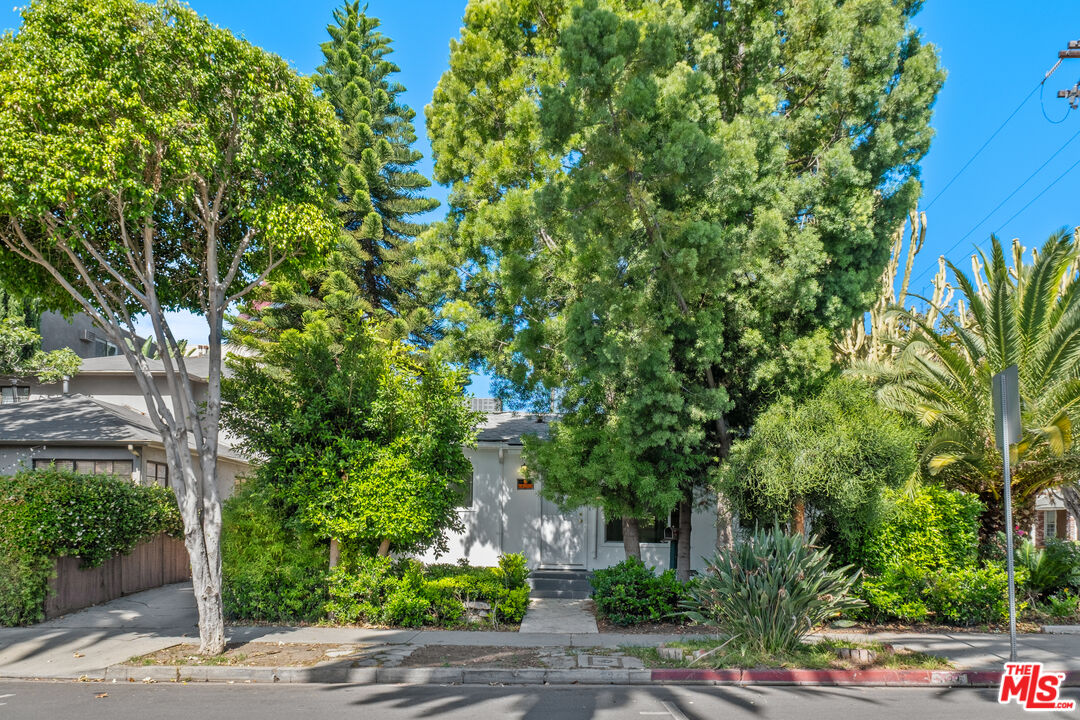 Street-facing home largely screened by mature trees and landscaping.