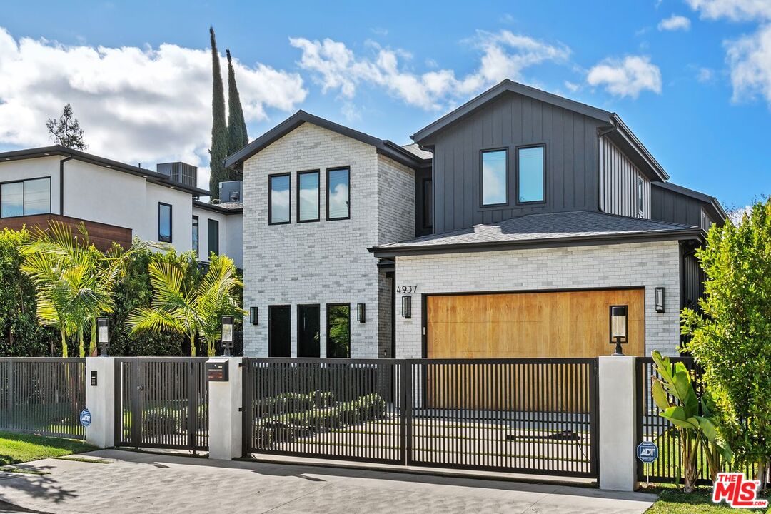 Modern two-story home at 4937 Rubio Avenue, with white brick and a wood garage door.