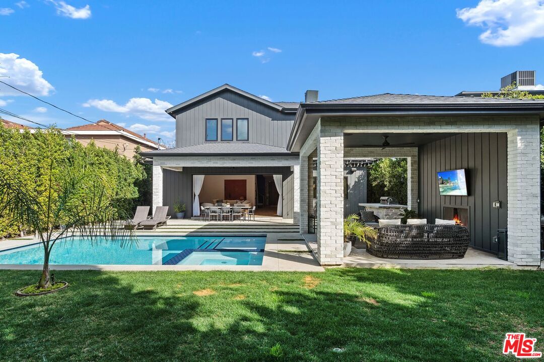 Modern home’s backyard with a swimming pool and furnished covered patio.