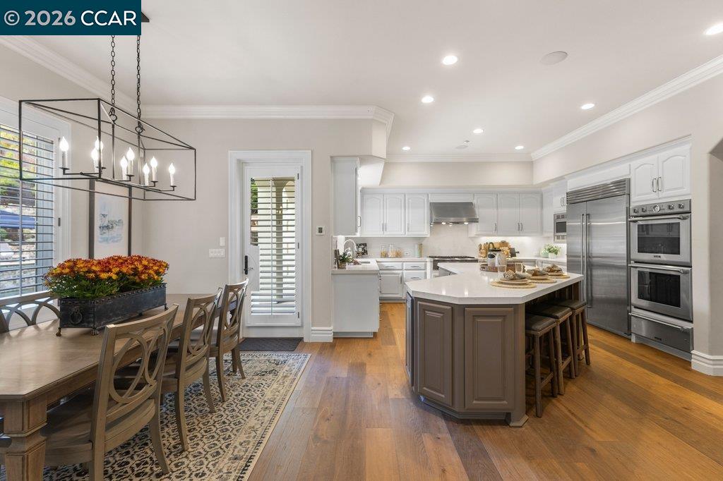 Kitchen with a large island, stainless steel appliances, and an adjoining dining area.
