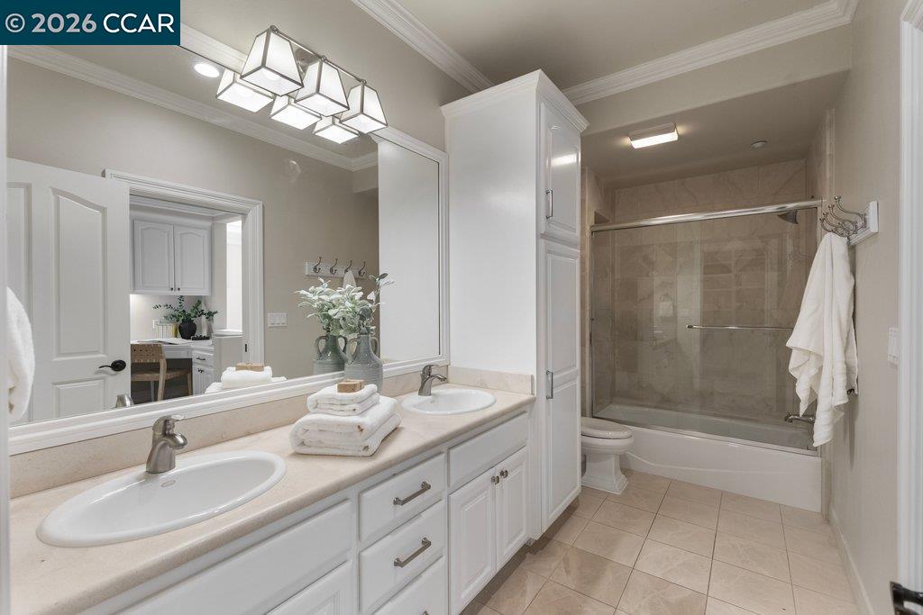 Bathroom with a double-sink vanity and tiled tub-shower.